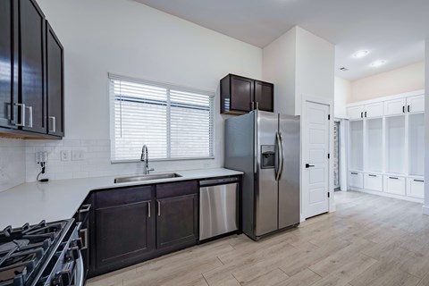 A kitchen with a stove top oven and a refrigerator.